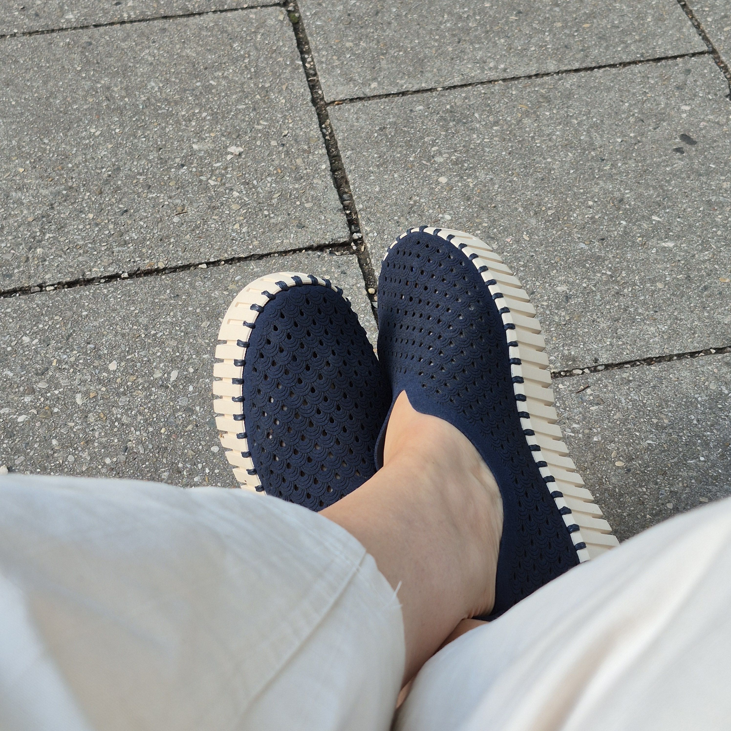 Überschlagen Füße mit dunkelblauen Schuhen.
